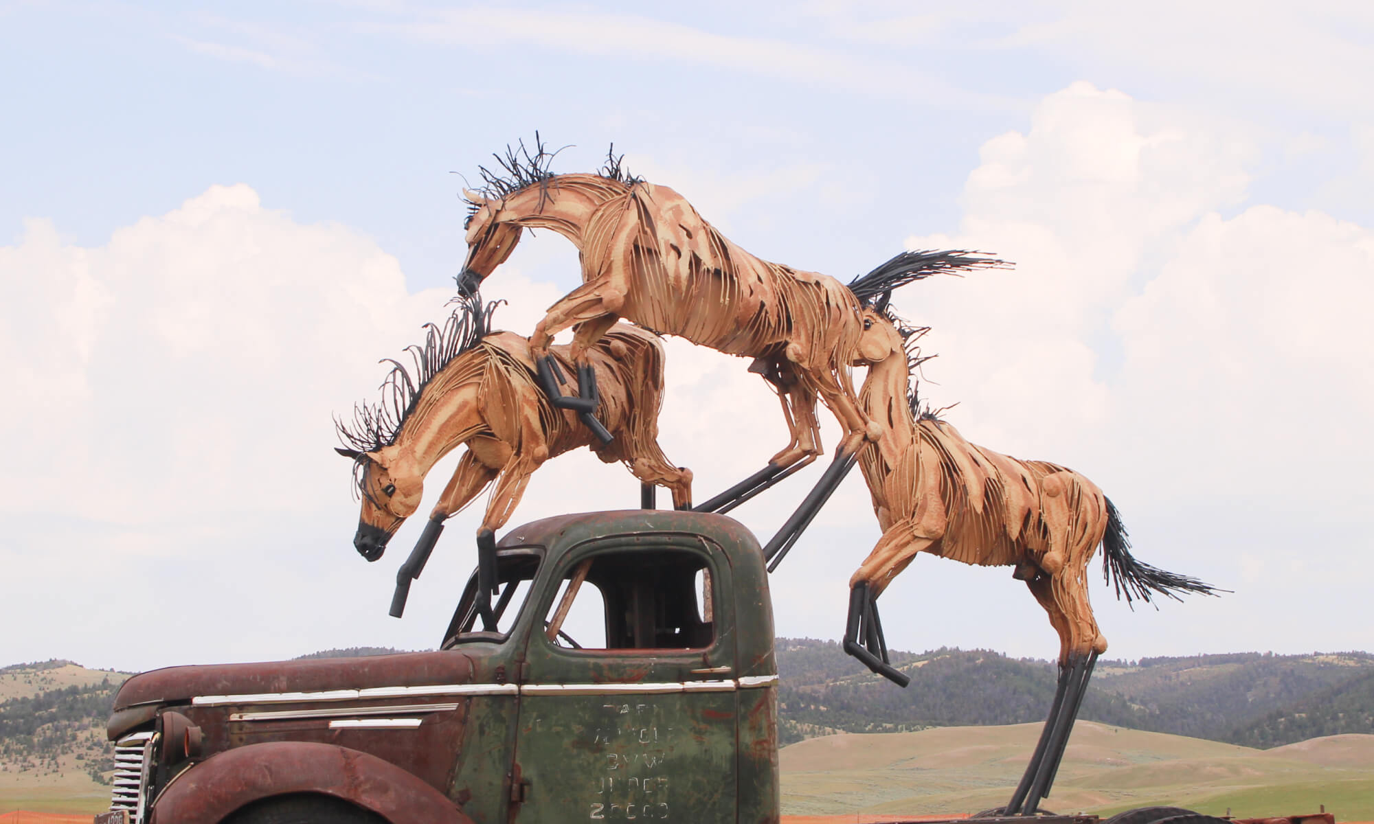 Jim Dolan sculpture called Three Buck Truck, with three horses running over the top of an old pickup truck