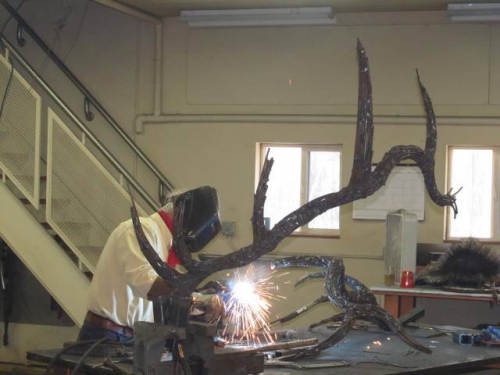Image of Jim Dolan welding an elk sculpture in studio