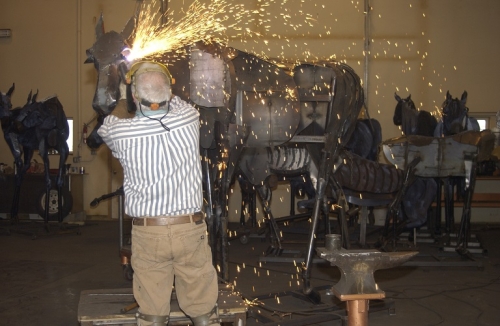 Image of Jim Dolan welding "Bleu Horse" sculpture in studio
